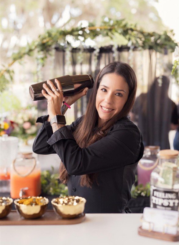 A Wild Bloom bartender shaking a signature cocktail
